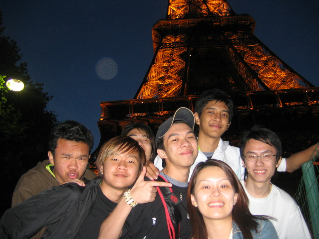GBR friends in front of the Eiffel Tower at night.